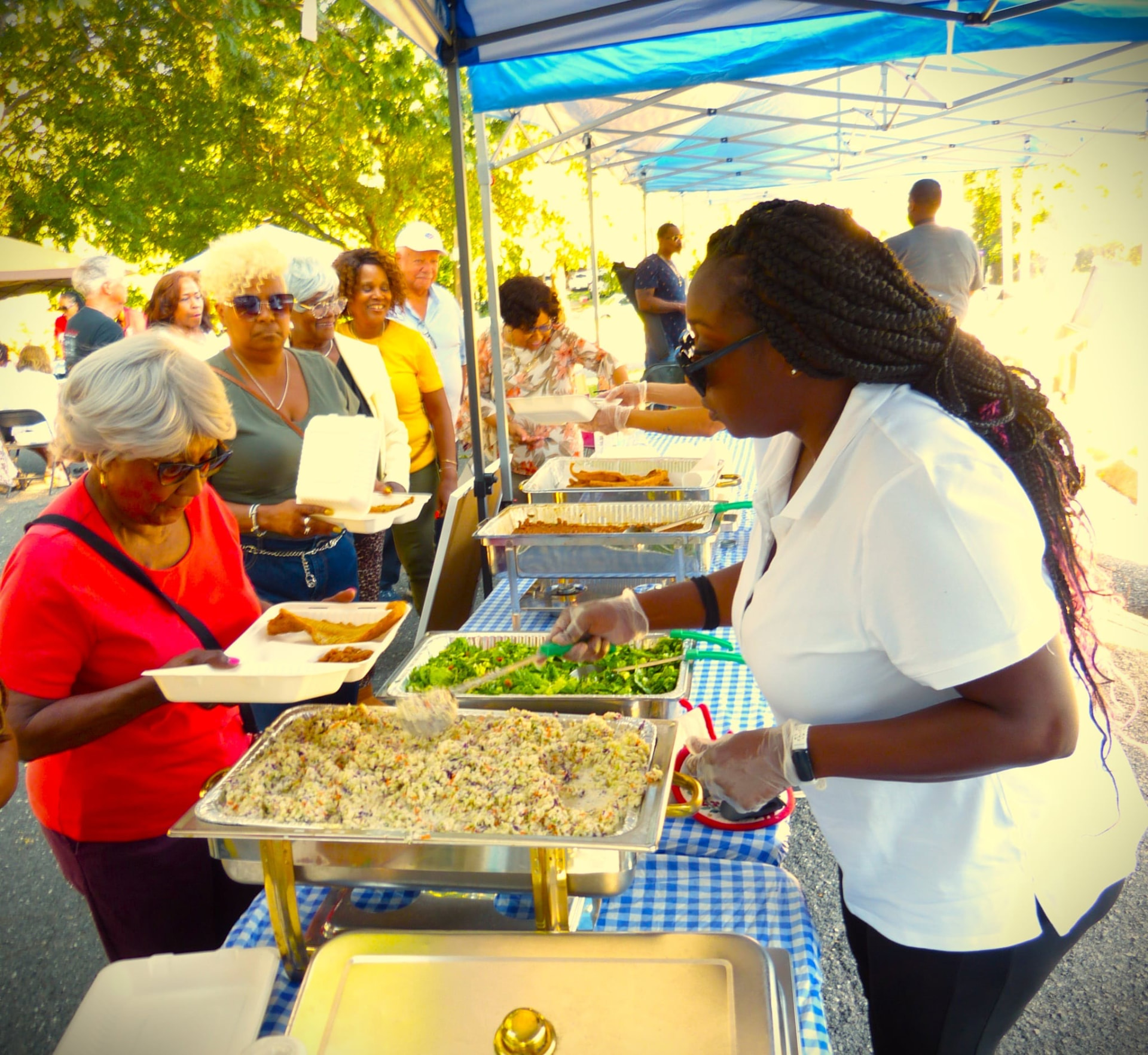 Volunteers serving plates of fish, slaw, and greens to neighbors at the Fish Fry